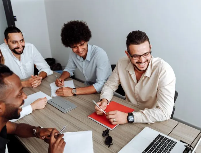 Equipe de agência reunida em volta de uma mesa, revisando resultados de campanha